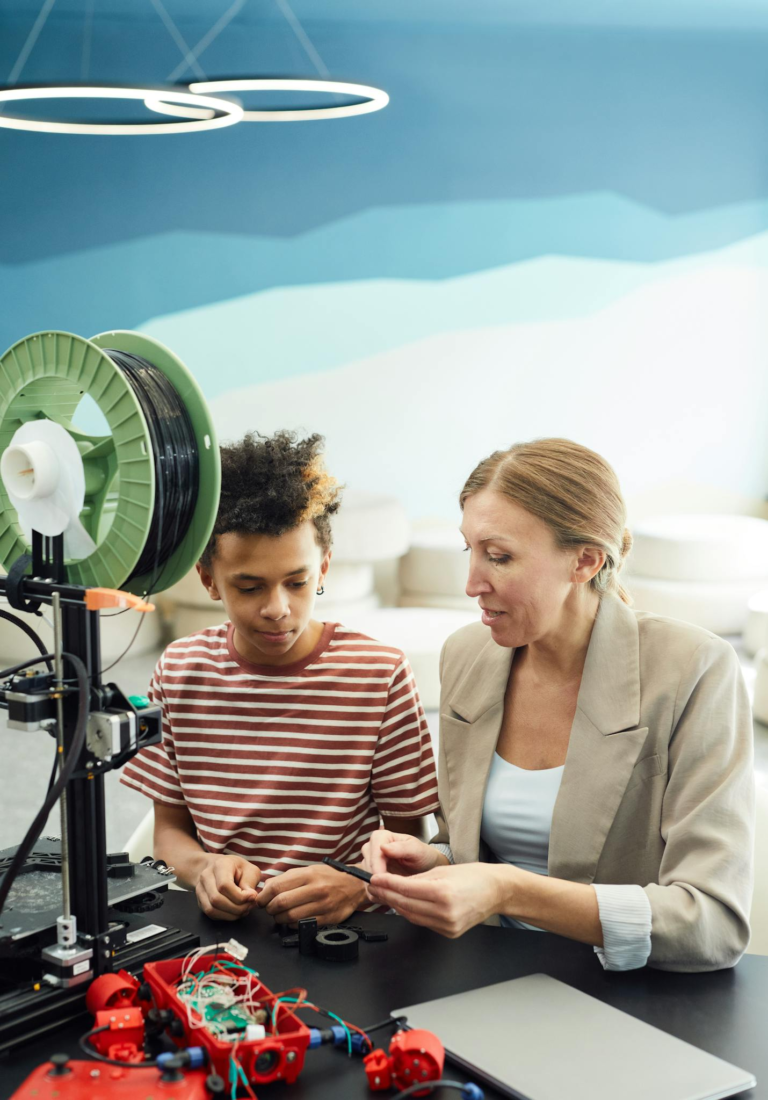 A child and adult engage in a learning session with a 3D printer, fostering STEM education.