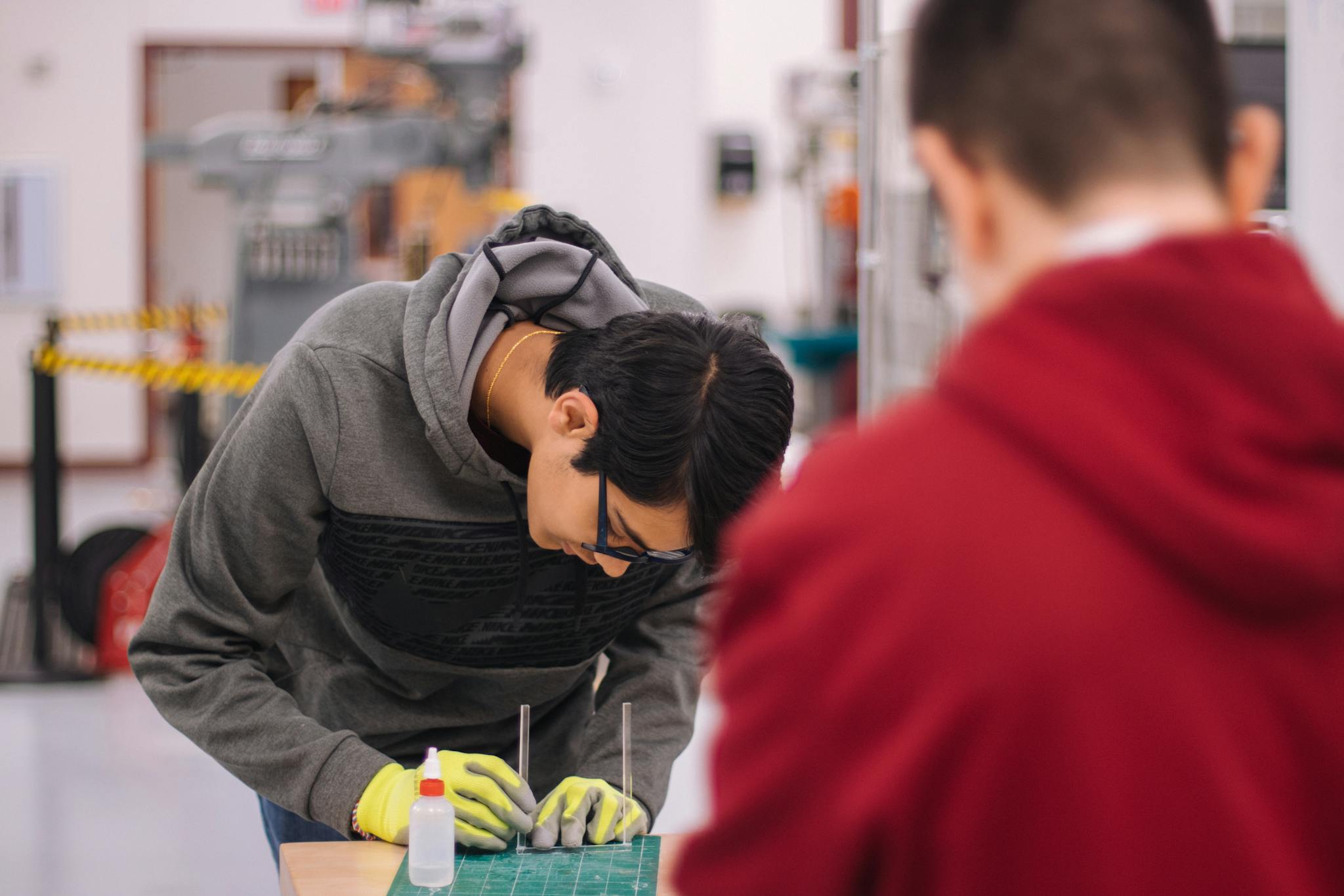 Two students working together in an engineering workshop with focus and precision.